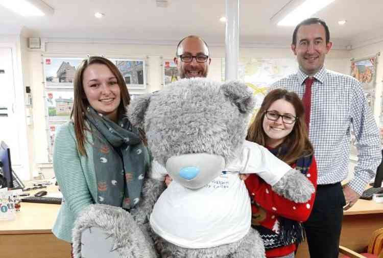 Members of staff at Greenslade Taylor Hunt estate agents in Honiton with Bertie the bear