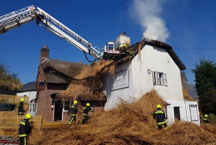 Firefighters tackle the thatch fire at The White Hart, Wilmington. Photo credit: Bridport Fire Station