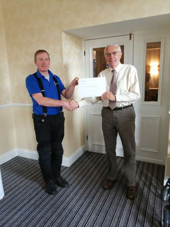 The Torquay and District Scottish Society presented Devon Freewheelers Blood Bikes volunteer and rider Rob Meadows with £550, for the charity. Credit: Torquay and District Scottish Society.