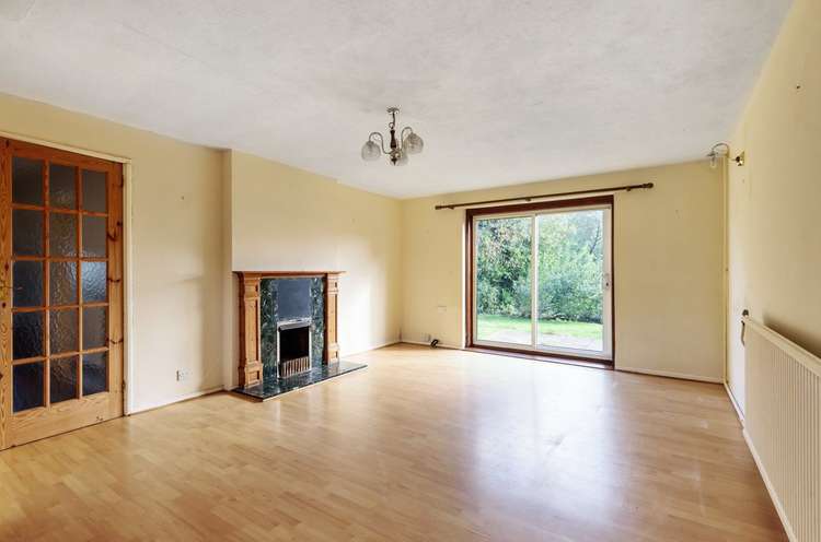 The living room has a feature fireplace and sliding patio doors to the garden