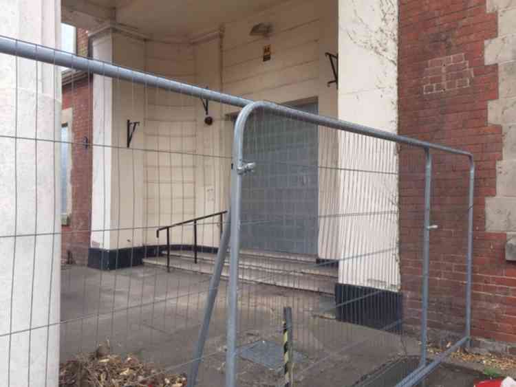 The entrance to the hotel is fenced off and boarded up