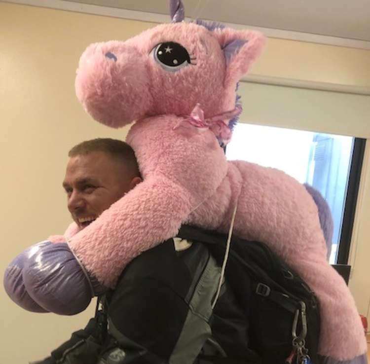 Shane Hasler with the unicorn that he won for his daughter (Photo: Bonnie Smith)