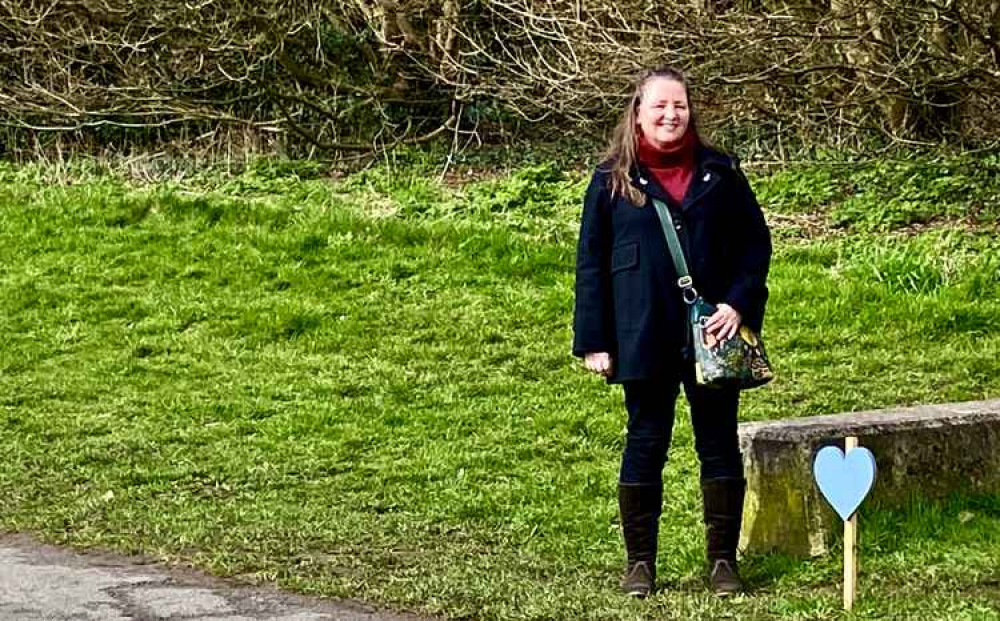 Cllr Barbara Kneale alongside the Blue Heart on Lower Packington Road and the area to be used for re-wilding