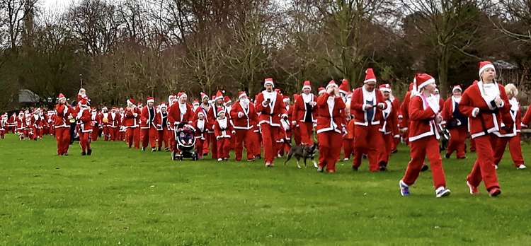 The line of Father Christmases stretched out across the Bath Grounds