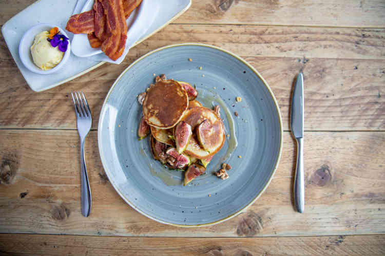 American-style pancakes, filled with roasted figs, topped with toasted walnuts, and drizzled with honey.