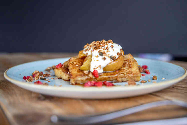 Cinnamon French toast, adorned with caramelised apples and crème fraiche, with a little extra crunch offered up by the nutty oat granola and crumbled raspberries.