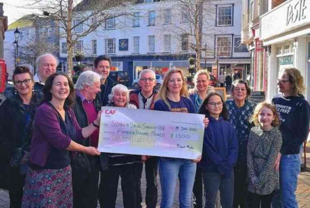 Kate Tobin from the Sid Vale Association's Keith Owen Fund grants committee presenting a cheque for the grant offered to SCCH Director Coco Hodgkinson, surrounded by the play's community cast.