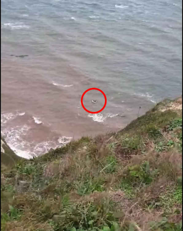 An image taken of the men in the dinghy by a Coastguard video.