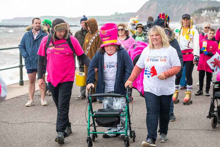 Charlotte walking past the finish line with dad, Steve and mum, Angie.