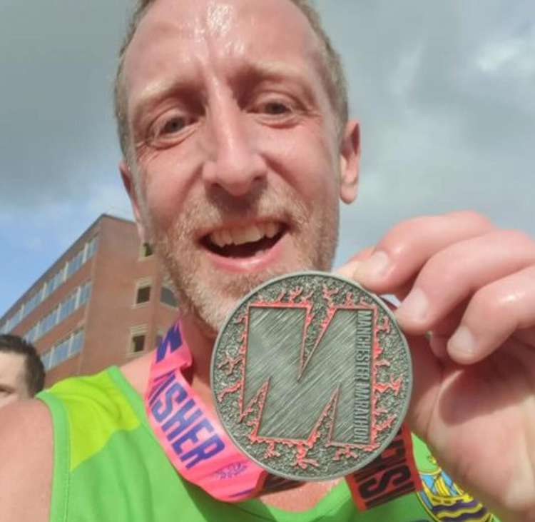 Antony Hall proudly displays his Manchester Marathon medal