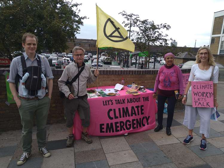 Extinction Rebellion Battersea with their pink table outside Asda. From left, Joe with new baby Orson, Steve, Ranjan and Pat (Image: Extinction Rebellion)
