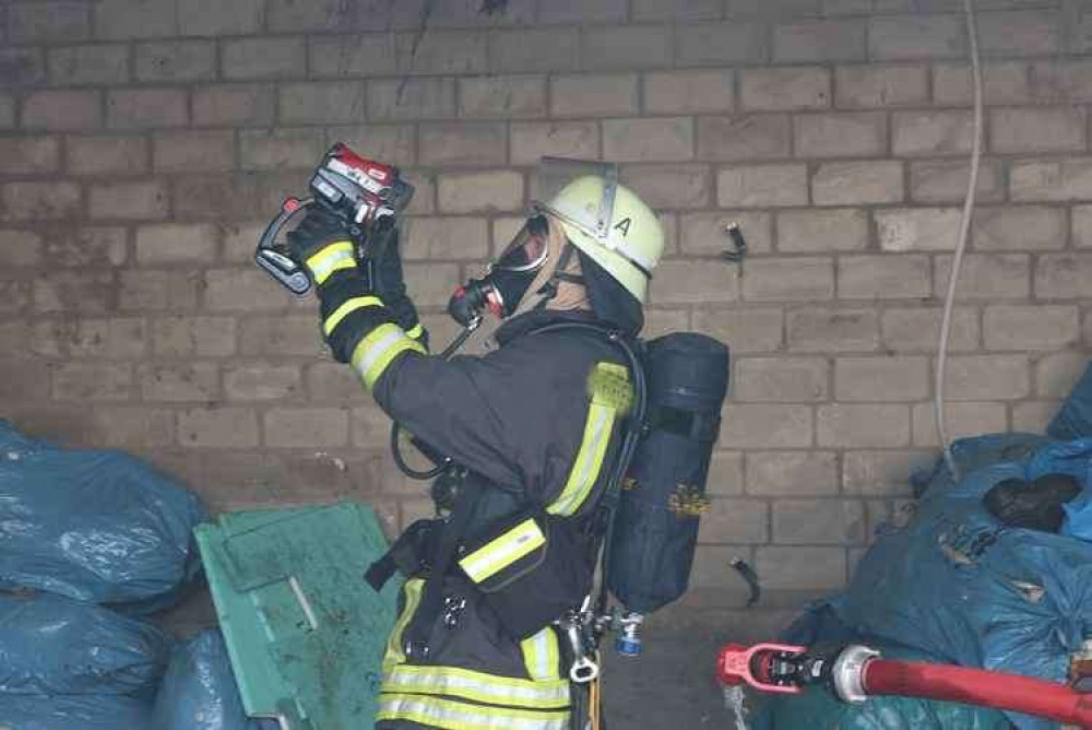 A member of a fire service with a thermal imaging camera.