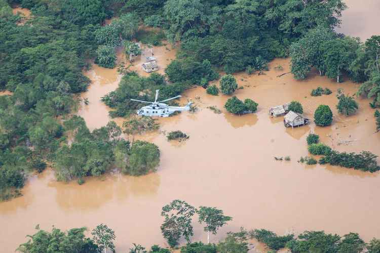 A merlin helicopter flies over a flooded Honduras. Credit: Royal Navy.