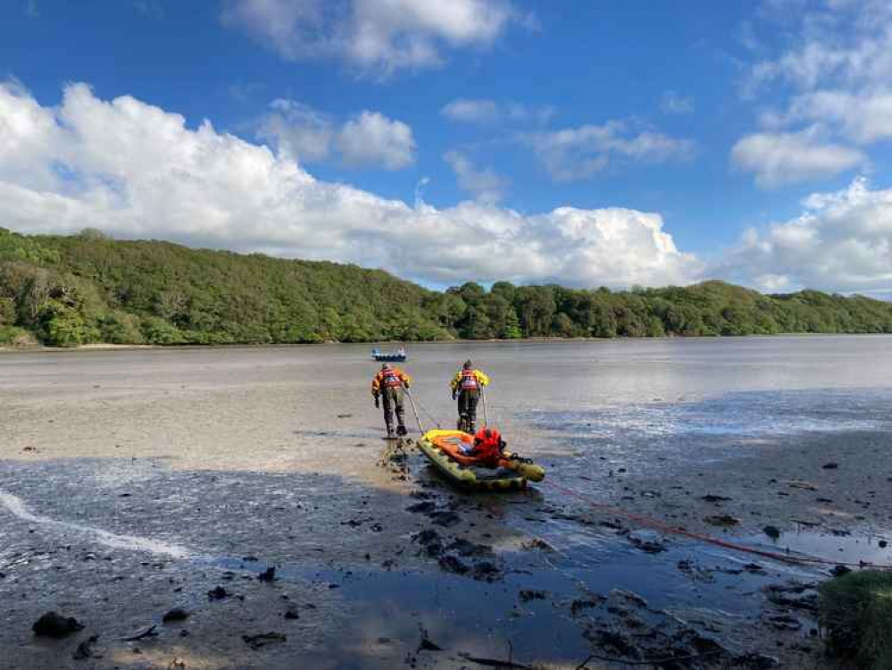 The coastguard team braving the mud to recover the casualty.