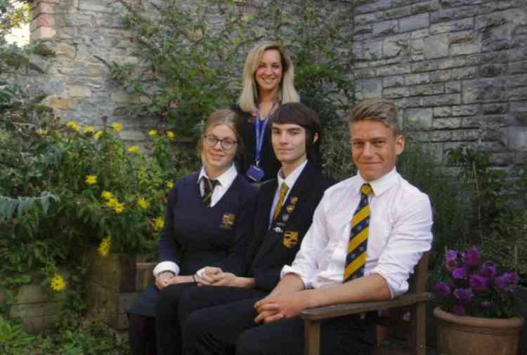 Lydia Crowter (back), Media Studies Teacher and Healthy Schools Coordinator; left to right on the bench is Niamh Rind (Year 11), Neil Power (Head Boy, Year 13) and Davis Hedgecoe (Year 11), who took the assessors on a tour of the school and gave a present