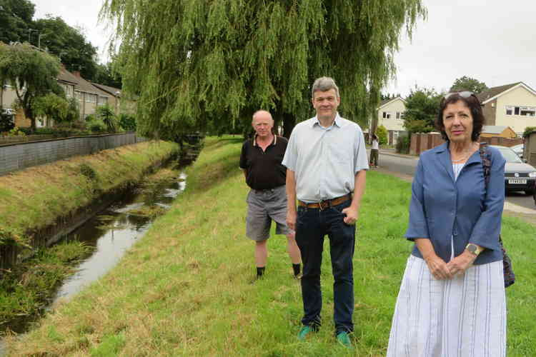 Plaid Councillors Anne Asbrey, Richard Grigg and Steve Thomas along side the stream in St Cadoc Avenue.