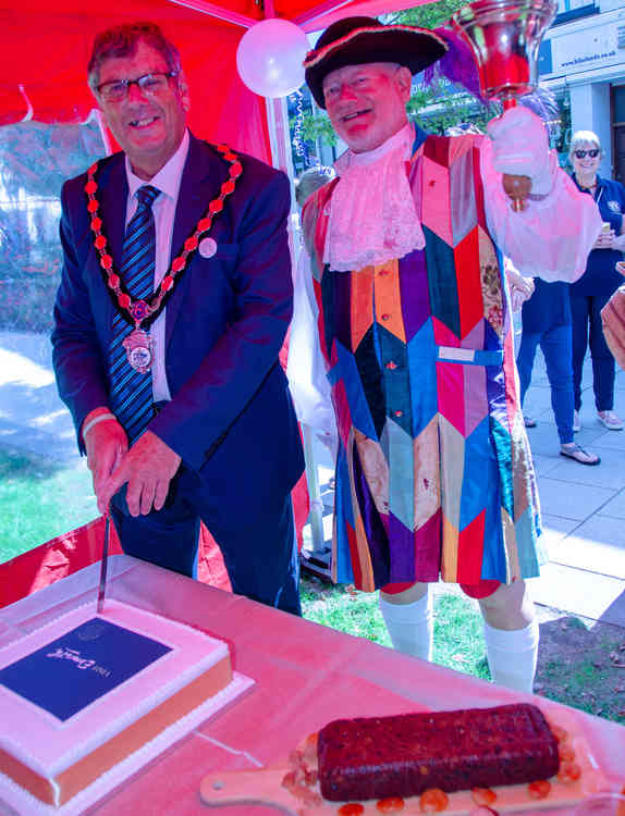 L – R Steve Gazzard, Town Mayor and Roger Bourgein – the Town Mayor cuts the official cake to launch the new Tourist Information Service . Credit : John Thorogood