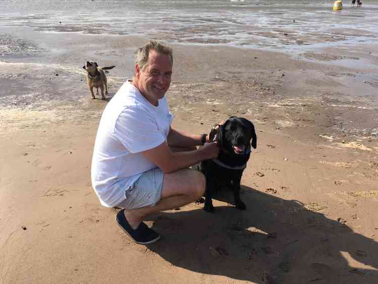 Paul Ashcroft, aka the Legal Beagle, walking his dog on the beach.