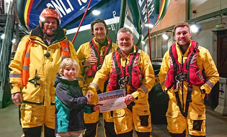 Aubrey is presented with his certificate by Exmouth RNLI Dept. Coxswain, Scott Ranft