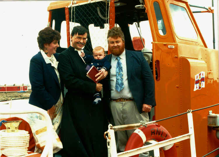 Tim and Mel Mock with Revd. Dr Geoff Harris conducting Henry's christening, May 1995.