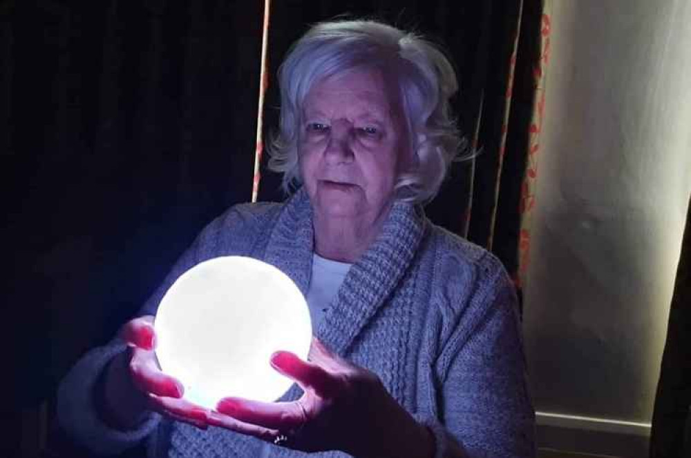Belong resident Ann Black, 78, inspects a moon lamp as part of the Astronomy Club's activities.