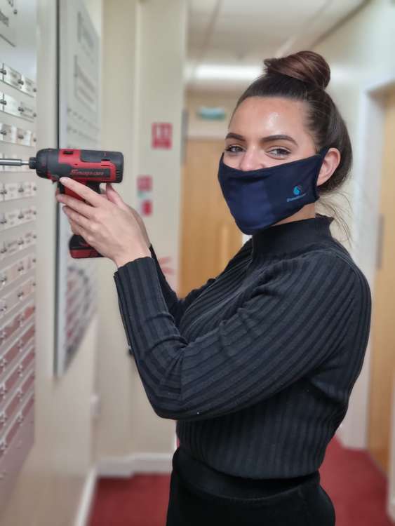 Laura Sumner makes adjustments to the long-service board at Swansway's head office.