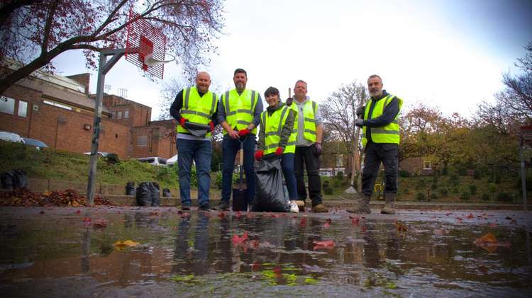 Donatable members clean up the basketball court at Flag Lane Baths.
