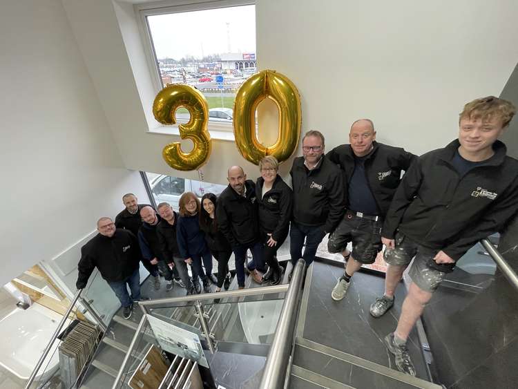 Staff at Ceramic Tile and Bathroom Supplies celebrate the firm's 30th year in business.