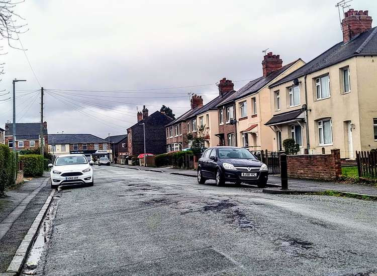The risen road, covered with potholes on Cliffe Road, Crewe.