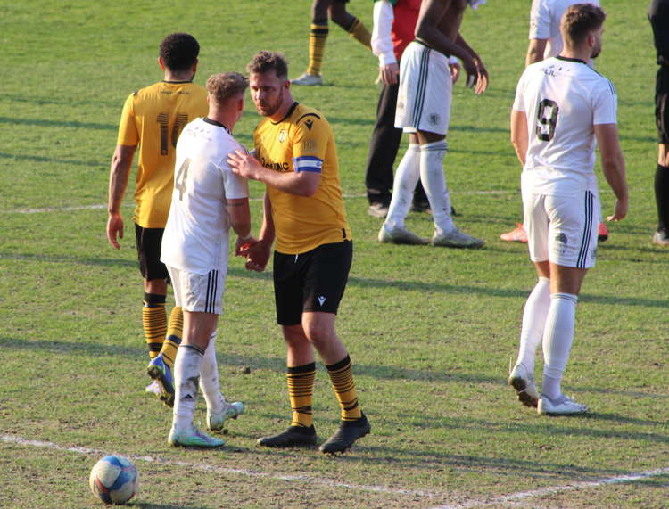 Ex-Railwaymen player Tom Pope shakes hands with Macclesfield's Lee Jackson.