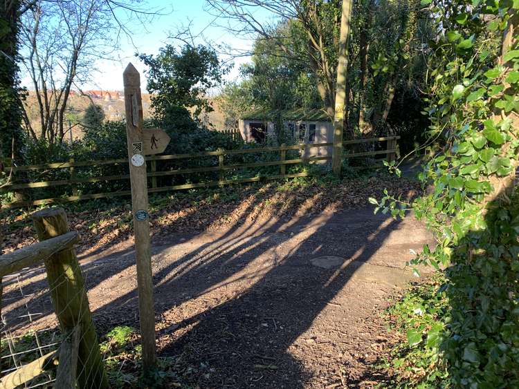 Cross over the lane to go down the footpath opposite