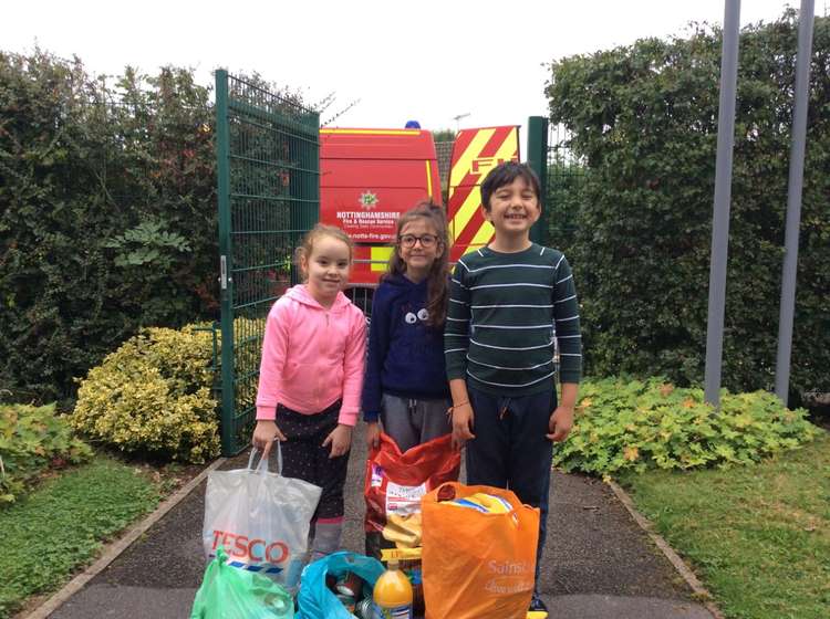 Students at Holy Cross with some of the food ready to be collected by Hucknall firefighters. Photo courtesy of Holy Cross Primary Catholic Voluntary Academy.