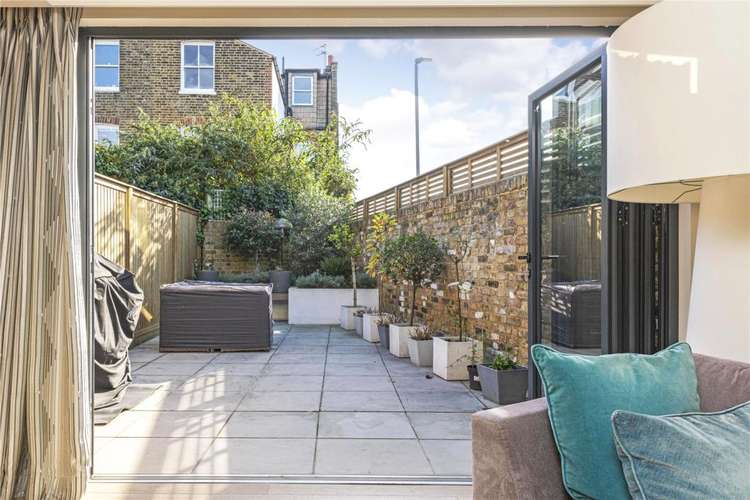 Bifold doors open onto a smart patio garden with raised beds (Image: Rampton Baseley)