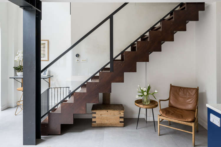 A contemporary timber staircase descends to the lower-ground floor (Image: The Modern House)