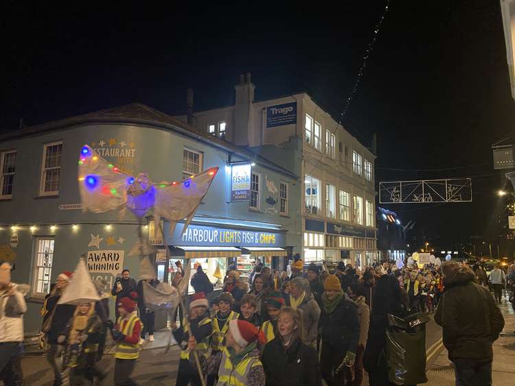 Crowds go through the street in the Christmas parade.