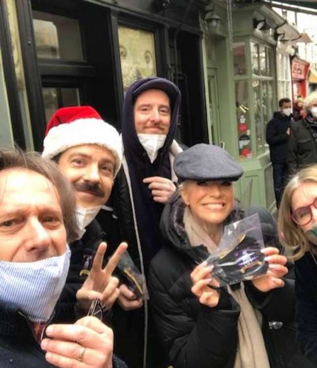 Actors Jason Sudeikis (in Santa hat) who plays Ted Lasso and club owner Rebecca (in peak cap) played by Hannah Waddingham outside his Richmond TV home