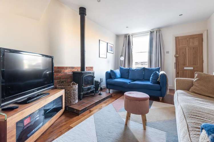 The cosy living room has a wood burning stove (Image: Gibson Lane)