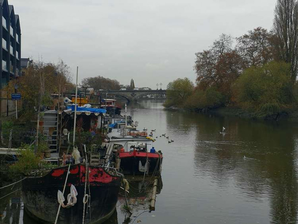 House boats on the Thames in Brentford and Kew Bridge in the distance.