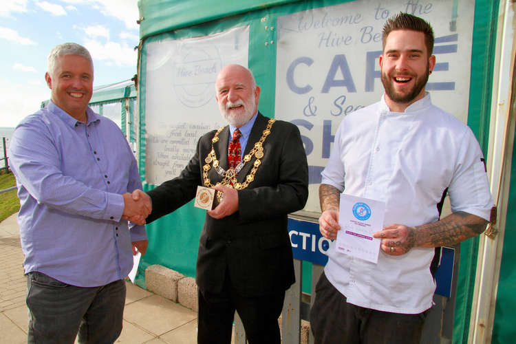 Bridport mayor, Ian Bark, presents a Plastic Free Champion Award to Hive Beach Cafe's operational manager, Andrew Hartley, left, and executive chef, Lewis Ford, for Hive Beach Cafe and The Club House at West Bexington