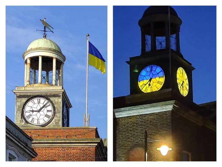 The flag flying above the town hall and the clock lit up in yellow and blue