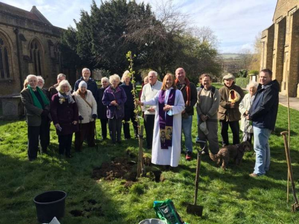 The Rev Deb Smith and parishioners plant the crab apple donated by Bridport Tree Planting in St Mary's churchyard