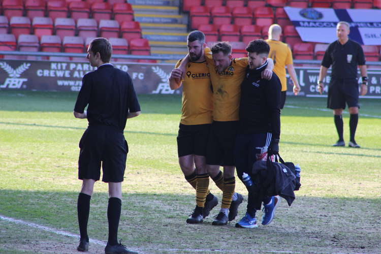 Congleton Player and Manager Richard Duffy - with Personal Trainer Jack Draper - help William Buckley off the pitch.