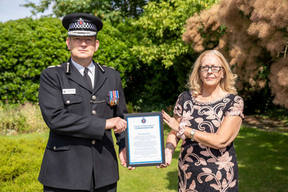 Chief Constable Ben-Julian Harrington presents the award to Lynda Wilson