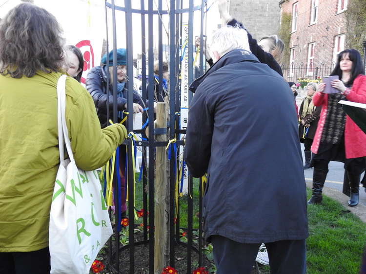Tying the ribbons to the Peace Pole. Picture by Micheal White
