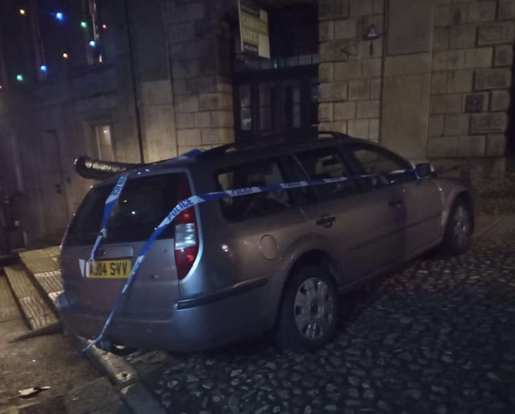 The car outside The Red Lion with police tape on it.