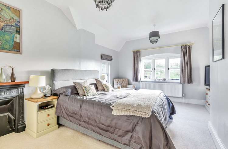 The bedroom is large and offers a feature fireplace. Credit: Bradleys Honiton.