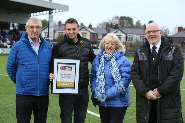 NWCFL Director Martin Fallon presented the framed certificate to Macclesfield owner Rob Smethurst, with supporters Trevor and Beryl Jones looking on. (Image - NWCFL)