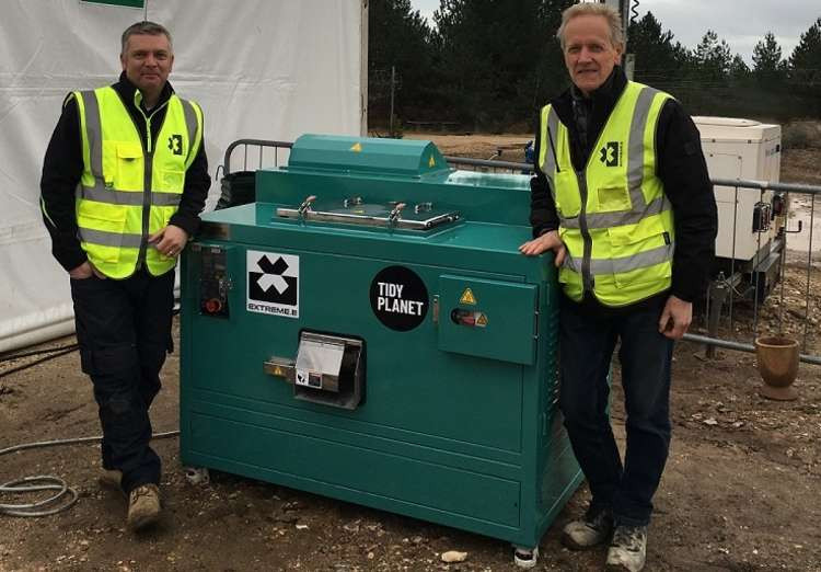 From left to right: Huw Crampton sales manager at Macclesfield's Tidy Planet and Andy Welch Extreme E's utility manager - with food waste drying equipment at the Bovington site. (Image - Tidy Planet)