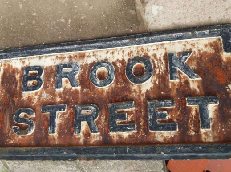 Brook Street's current Victorian-style street sign is propped up by the floor.