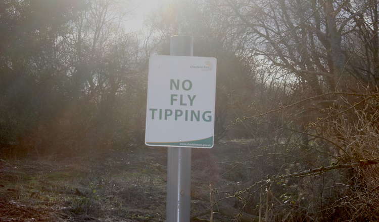 A sign discourages littering off've Moss Lane.